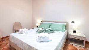 Un dormitorio con una cama con toallas. en Sardinianworld - Domo Mea Apartment, en Cabras