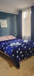 a bed with a blue blanket with stars on it at Guest House Guli in Mestia