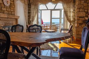 una sala da pranzo con tavolo e sedie in legno di Fener burnunda Denize sıfır orjinaltaş malikane a Çeşme