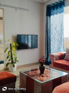 sala de estar con TV de pantalla plana en la pared en SOLACE Premium 3BHK Apartment Manyata Tech Park and Mall of Asia en Bangalore