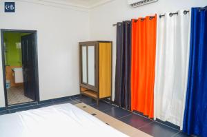 Habitación con cortinas de ducha coloridas y espejo. en La bonté, en Abomey-Calavi