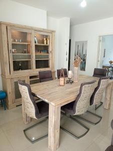 a dining room table with chairs and a wooden tableablish at New apartment in Tilal Fanar resort pool Tennis in Beit Meri