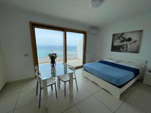a bedroom with a bed and a glass table with a view at Casa Vacanza Acquamarina in Porto Torres