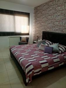 uma cama grande num quarto com uma parede de tijolos em New apartment in Tilal Fanar resort pool Tennis em Beit Meri