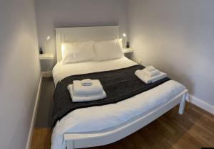 Tranquil Haven Retreat في Lexden: غرفة نوم عليها سرير وفوط