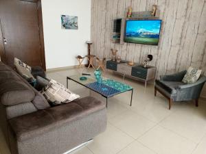 uma sala de estar com um sofá e uma mesa em New apartment in Tilal Fanar resort pool Tennis em Beit Meri