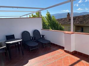 Un patio con sillas y una mesa en el balcón. en Hotel el Sol en Lanjarón