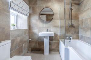 a bathroom with a sink and a tub and a toilet at Haven View - 2 Bedroom Apartment - Milford Haven in Milford Haven +33 photos