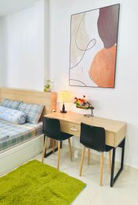 a bedroom with a desk and a bed and a table and chairs at Dragonfly Village in Ho Chi Minh City