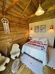 - une chambre avec un lit dans une cabane en rondins dans l'établissement Recanto dos Pássaros, à Caparaó Velho