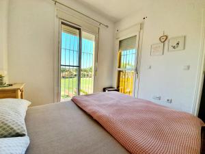a bedroom with a bed and a large window at ALBATROS GOLF - ISLANTILLA in Islantilla +8 photos