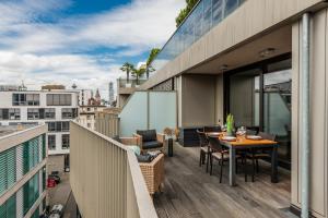 un balcon avec une table et des chaises sur un immeuble dans l'établissement Klassen Stay - Exklusives Luxus Loft am Dom - Dachterrasse, Traum-Aussicht, à Cologne
