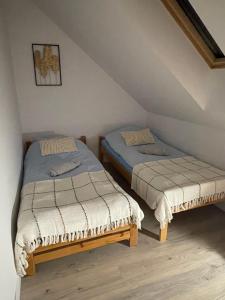 two twin beds in a room with a attic at Bezdroża Mazurskie in Mrągowo