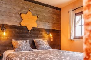 una camera da letto con un letto con una parete in legno di Les Auzerals camping du lac a Rabastens