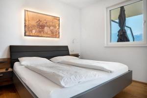 two beds in a bedroom with a picture on the wall at Bacchushof Apartment Merlot in Termeno +25 photos