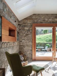 un soggiorno con una parete in pietra e una finestra di June Blake's Garden a Blessington
