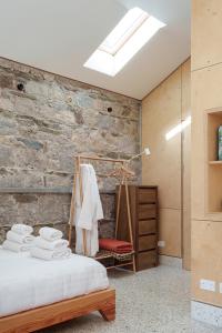 - une chambre avec un lit et un mur en briques dans l'établissement June Blake's Garden, à Blessington