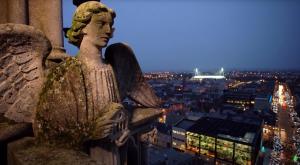 an angel statue on top of a building at night at Les Rives Rémoises in Reims