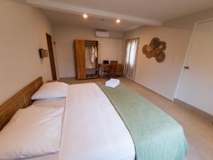 a bedroom with two beds and a table at Nos Casita - 5 min walk to the beach in Pos Chiquito