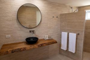 a bathroom with a black sink and a mirror at Nos Casita - 5 min walk to the beach in Pos Chiquito +32 photos