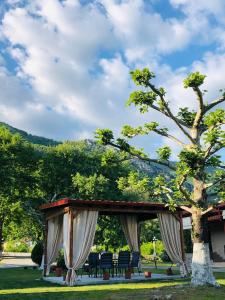 a gazebo with chairs and a tree at Paradise Studios in Kato Loutraki