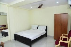 1 dormitorio con 1 cama y 1 silla en ARUNA GRAND en Visakhapatnam