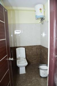 a bathroom with a white toilet in a room at ARUNA GRAND in Visakhapatnam