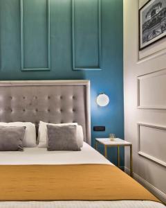 een slaapkamer met een bed met blauwe muren bij 23 Boutique Hotel in Il-Furjana