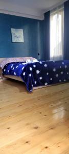 a bed with a blue blanket with stars on it at Guest House Guli in Mestia