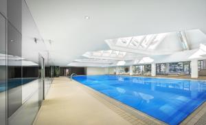a large swimming pool with blue water in a building at Aminess Vival Maestral Hotel in Novigrad Istria