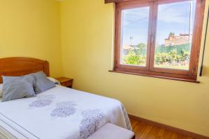 - une chambre avec un lit et une fenêtre dans l'établissement APARTAMENTOS OLGA, à Cudillero