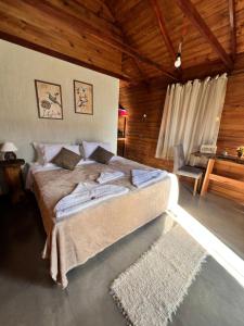 - une chambre avec un grand lit et un bureau dans l'établissement Recanto dos Pássaros, à Caparaó Velho