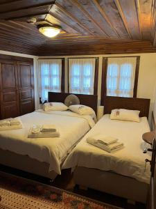 two beds in a room with two windows at SEMRA HANIM KONAĞI in Safranbolu