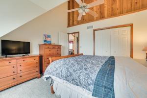 una camera da letto con un letto e una TV a schermo piatto di Family-Friendly Houghton Lake House Steps to Lake a Houghton Lake