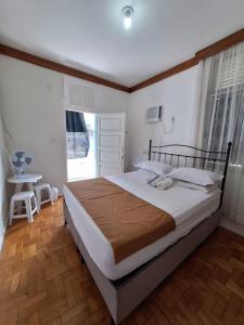 Un dormitorio con una cama grande y una ventana en Quartos Aconchegantes prox Pelourinho, Metrô e Arena F Nova, en Salvador