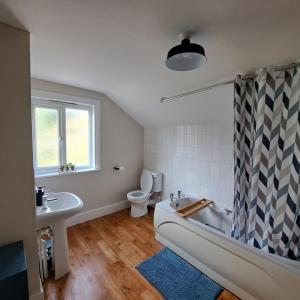 ein Badezimmer mit einer Badewanne, einem WC und einem Waschbecken in der Unterkunft Generous 3 bed in the heart of the village in Huntingdon