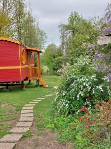 un jardín con una casa y un sendero ajardinado en Roulotte ZEN, 