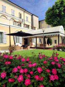 un giardino con rose rosa di fronte a un edificio di Rechigi Park Hotel a Modena