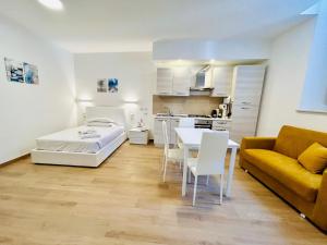a living room with a bed and a table and a couch at SMART SUITES FORLI' in Forlì