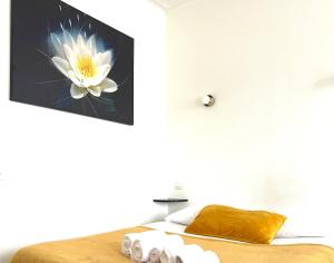 a bedroom with a picture of a flower on the wall at Hôtel Les Quais in Cherbourg en Cotentin