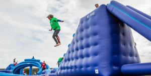 een meisje springt van een blauwe opblaasbare bij Dome Meadows 2 At Tapnell Farm in Yarmouth