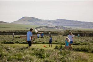 een groep mensen die spelen met een bal in een veld bij Dome Meadows 2 At Tapnell Farm in Yarmouth