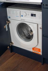 a washing machine in a kitchen with its door open at Cheeky and Beautiful Apartment in Greenwich in London