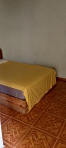 una camera da letto con un letto con un lenzuolo giallo di pablo guess house a Cap-Haïtien