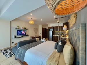 a bedroom with a large bed and a couch at Unwind | Private Balcony & Rooftop Pools | Casago in Tulum