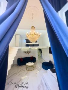 a living room with blue curtains and a chandelier at JACUZZI SINAGOGA view in Budapest