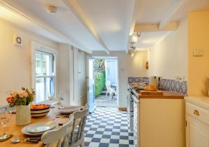 a kitchen with a table and chairs and a counter top at Melyn Wood Cottage in Little Petherick