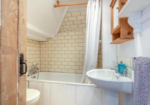 a bathroom with a tub and a sink and a toilet at Melyn Wood Cottage in Little Petherick