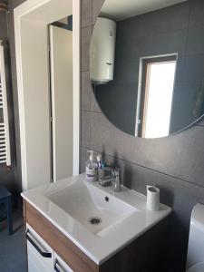 La salle de bains est pourvue d'un lavabo et d'un miroir. dans l'établissement Apartman Elma, à Bihać