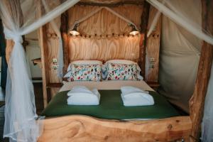 een bed in een tent met twee kussens bij Dome Meadows 2 At Tapnell Farm in Yarmouth